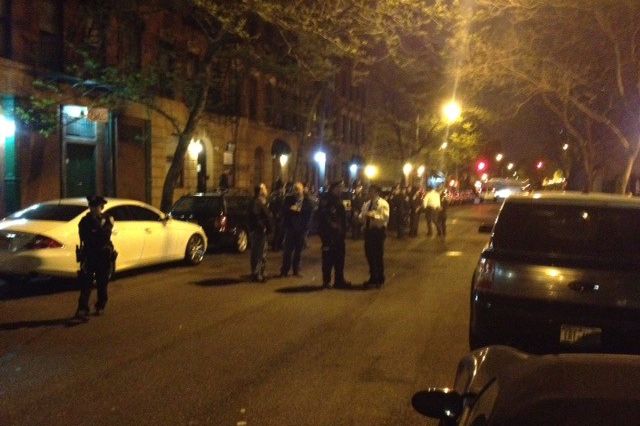 Police fill East Sixth Street to watch a group of people leave the Sixth Street Community Center